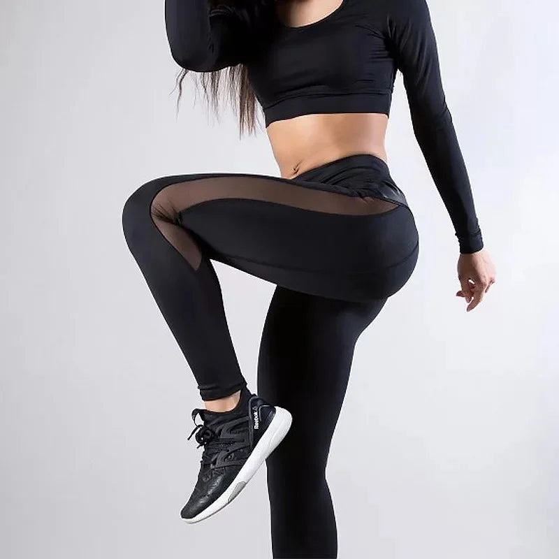 Woman wearing black workout attire striking a dynamic pose.