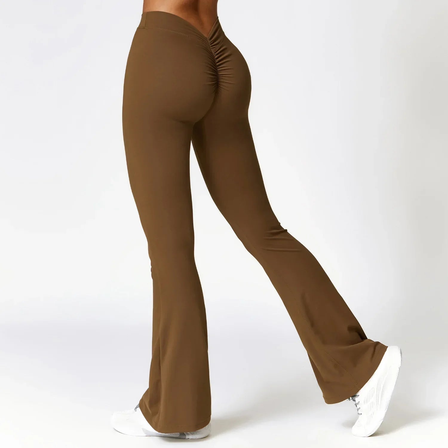 Brown flared yoga pants with a ruched detail at the back, worn with white sneakers.