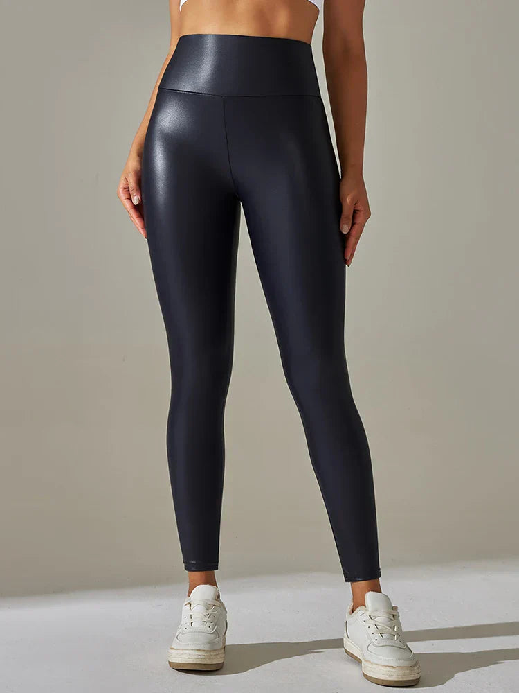 High-waisted black faux leather leggings worn with white sneakers.