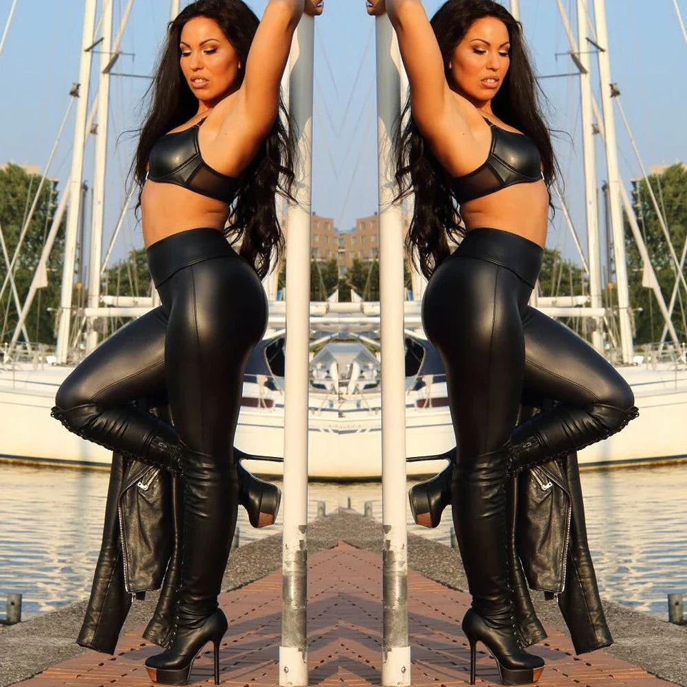 Woman in black leather outfit posing on a dock.