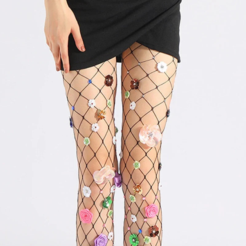 Fishnet stockings adorned with colorful floral appliqués and beads.