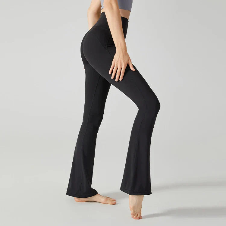 Black flared yoga pants or leggings worn by a person standing barefoot.