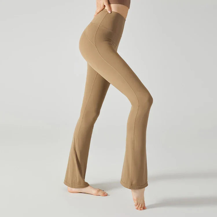 Beige flared yoga pants or leggings worn on a person’s legs and feet.