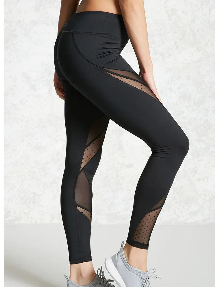 Black athletic leggings with sheer mesh panels and polka dot details.