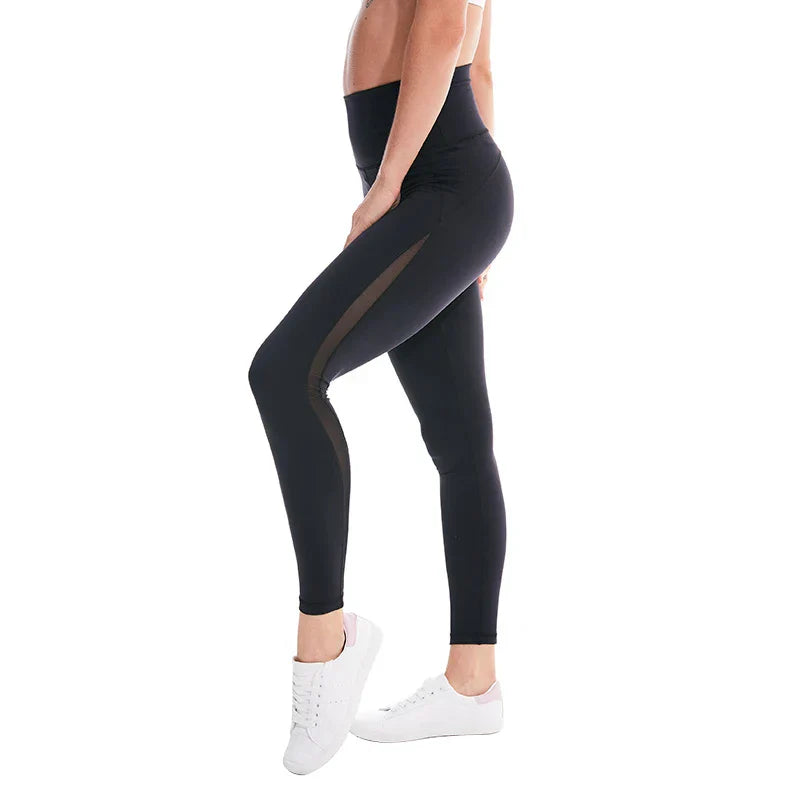 Black high-waisted athletic leggings worn with white sneakers.