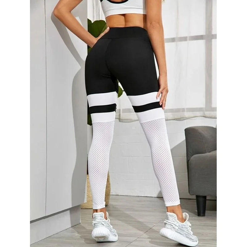 Black and white color-blocked athletic leggings with mesh panels.