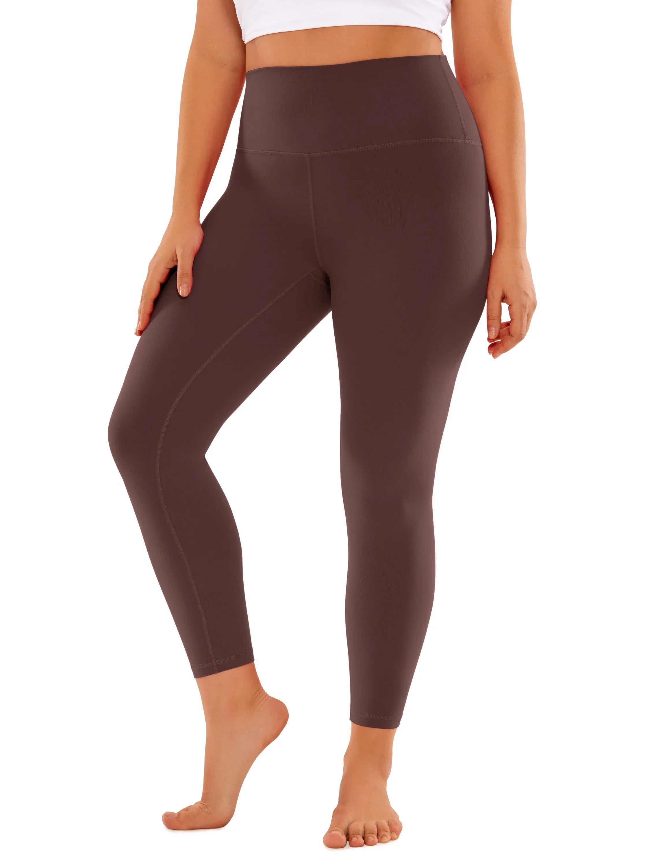 Brown high-waisted leggings or yoga pants worn by a person.