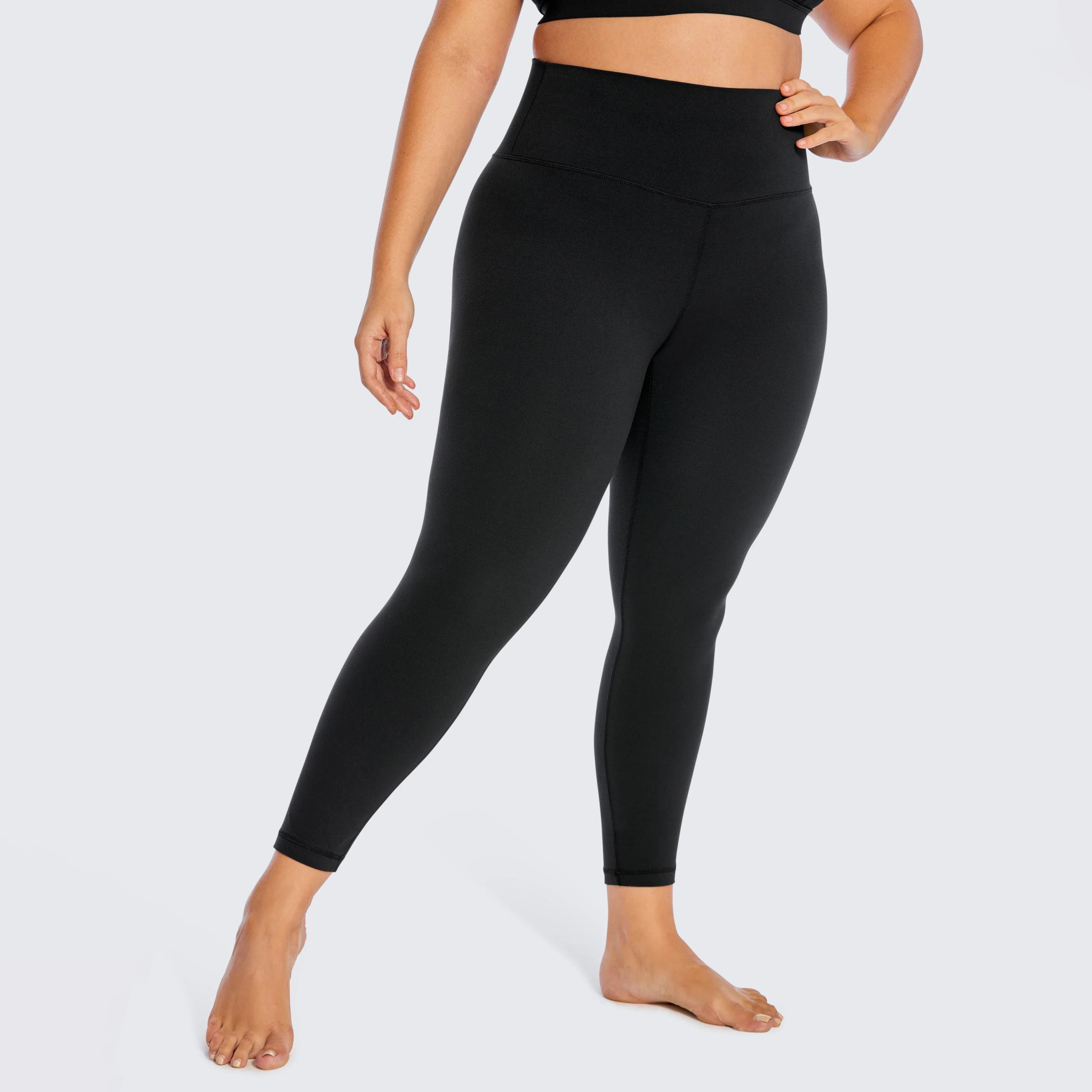 Black high-waisted leggings worn by a person with a curvy figure.